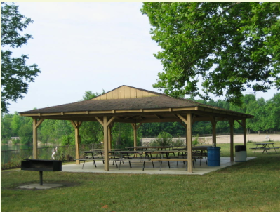 Shelter with picnic tables, grill with water in the background